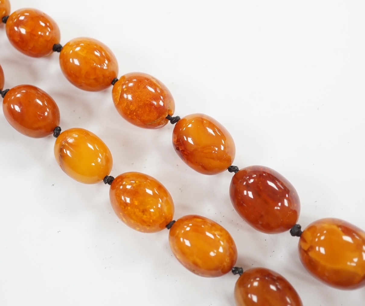 A single strand graduated oval amber bead necklace, 76cm, gross weight 107 grams. Condition - poor